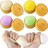 A hand is squeezing a yellow dumpling squishy stress ball with a mini steamer attached.