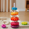 A colorful rainbow spinning stacking tower made of plastic rings in various colors like blue, orange, red, and purple.