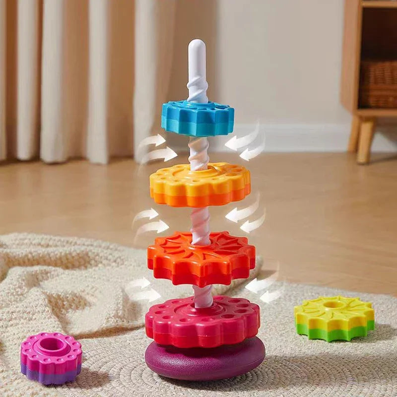 A colorful rainbow spinning stacking tower made of plastic rings in various colors like blue, orange, red, and purple.