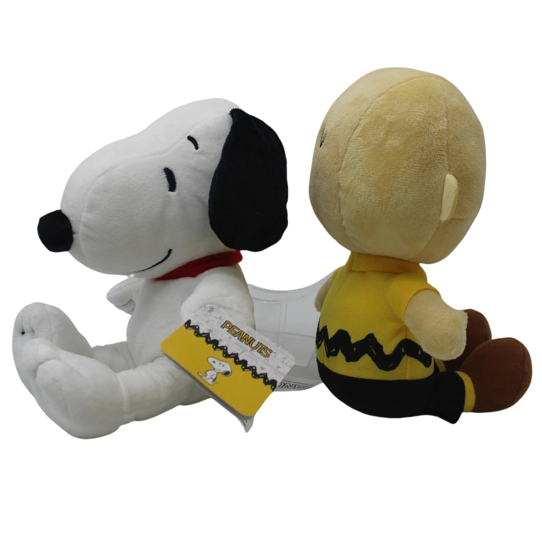 A soft collectible plush toy of Snoopy sitting next to a yellow character doll.