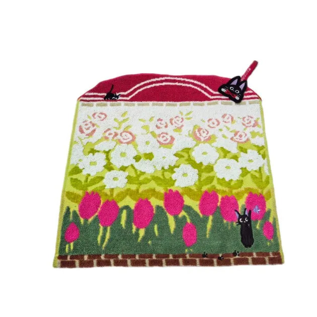 A red and green embroidered fabric featuring floral patterns and a black silhouette of a hippo.