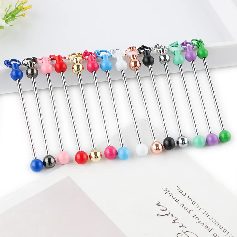 A collection of metal keychain bars with lobster clasps in various colors and finishes arranged in a line.