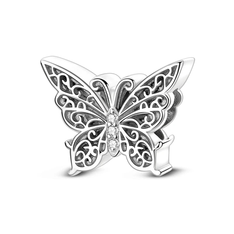 Silver charm bead shaped like a butterfly with intricate scrollwork and a central diamond detail.