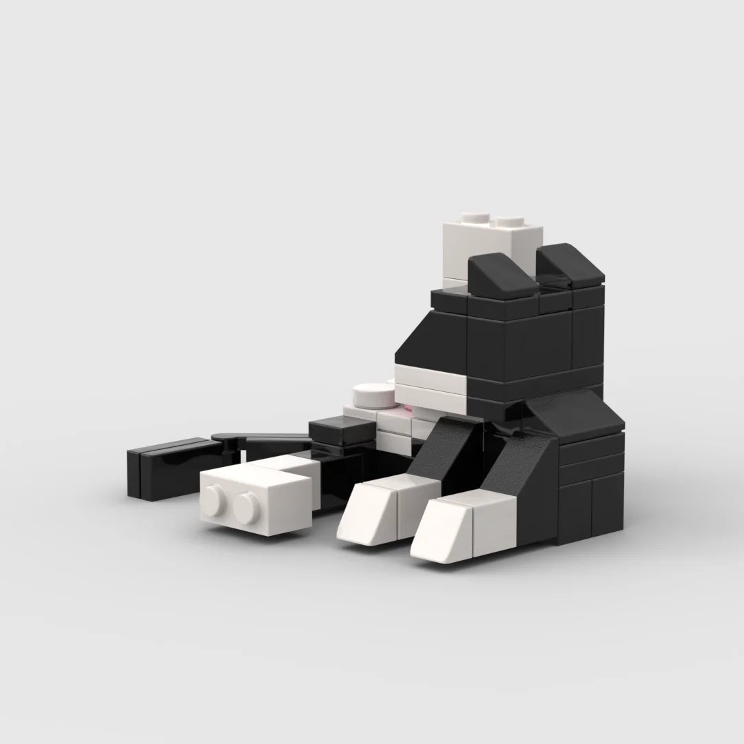 A collection of black and white animal building blocks stacked in a disorganized pile.
