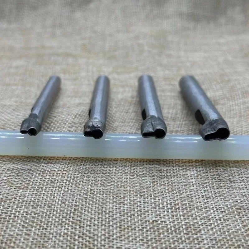 A set of five precision leather hole punches with metal tips resting on a white plastic rod.