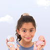A girl holds two realistic soft vinyl baby dolls with newborn outfits.