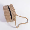 Handwoven straw crossbody bag with a lace bow, shown rolled up and with a long strap.