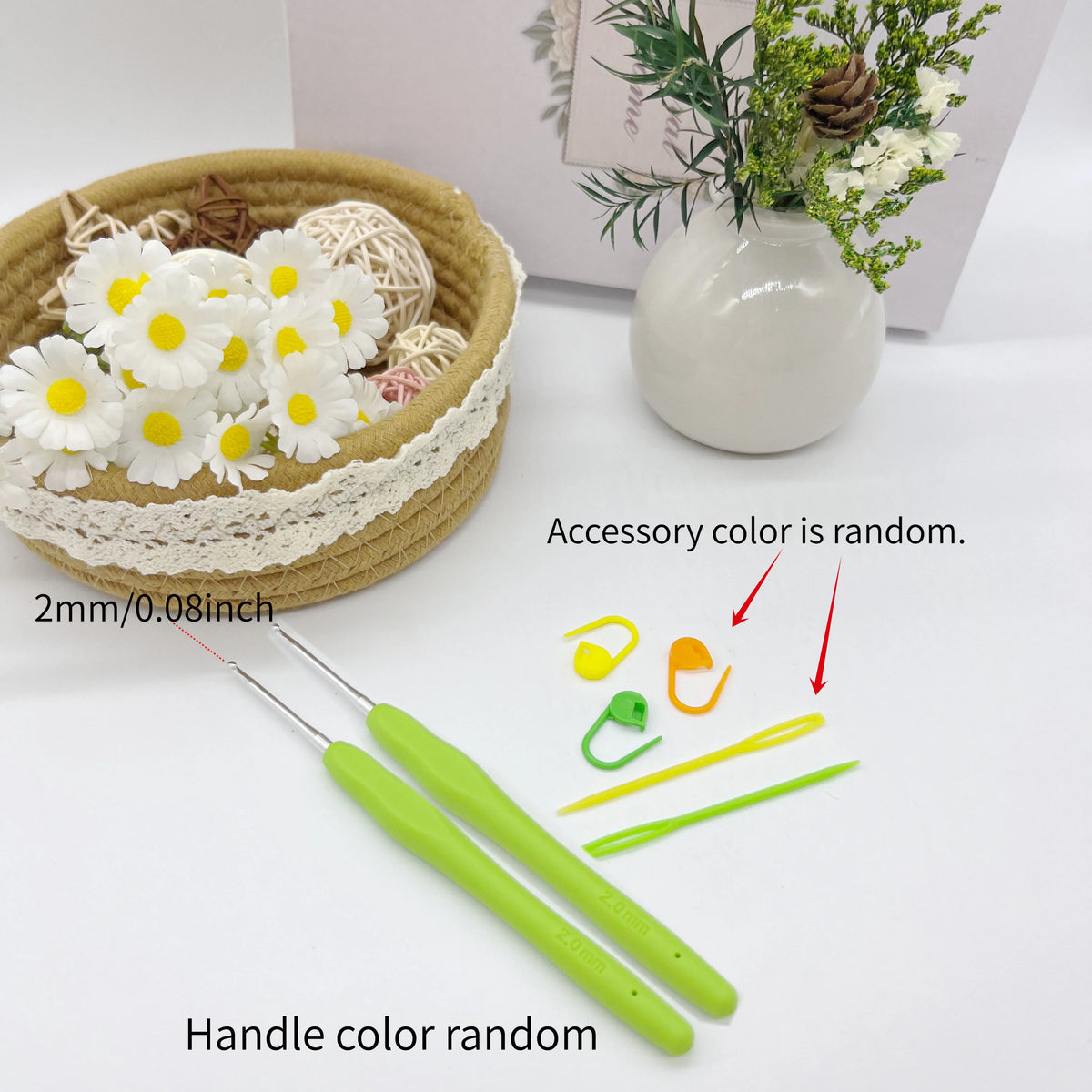 A set of crochet tools including a hook, stitch markers, and needles are displayed next to a potted plant.