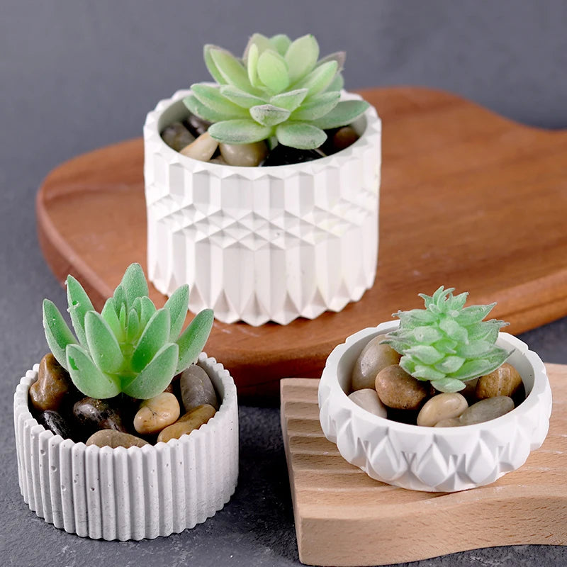 A white silicone mold holds a succulent plant in a decorative container on a wooden surface.