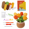A DIY potted plant crochet kit featuring colorful yarn balls, tools, and a finished crocheted plant in a pot.