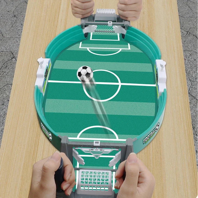 Hands are operating a portable tabletop foosball game with smooth-spinning rods on a wooden table.