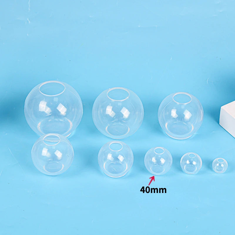 A set of clear silicone sphere molds used for resin crafting, shown against a light blue background.
