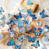 A set of blue and purple butterfly stickers for scrapbooking and journaling displayed on a wooden surface.