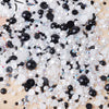 A pile of mixed resin rhinestone pearls with an AB finish in black and white for crafts and nail art.