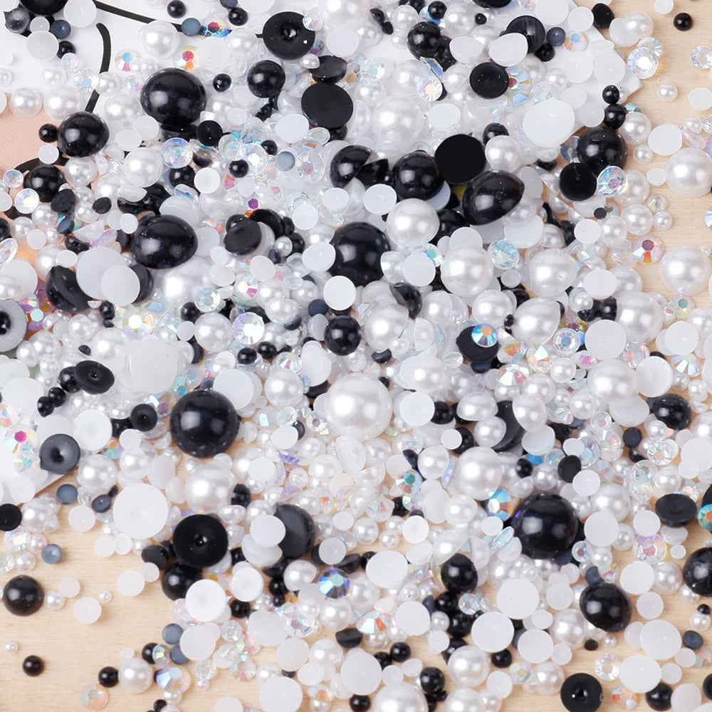 A pile of mixed resin rhinestone pearls with an AB finish in black and white for crafts and nail art.