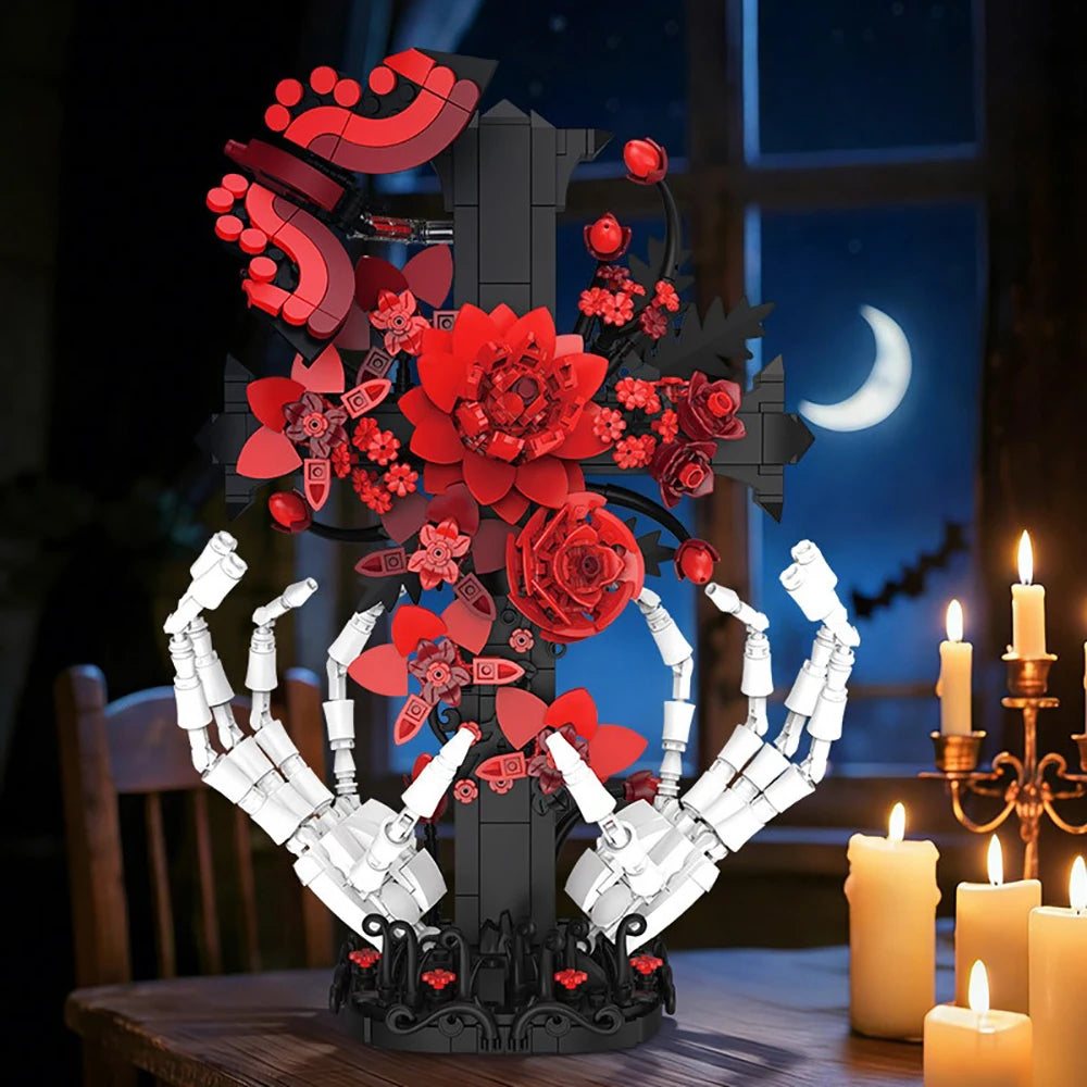 A dark gothic skeleton hand and rose cross building set displayed on a wooden surface.