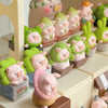 A collection of pink and green pig figurines from the Lulu the Piggy Garden series blind box set.