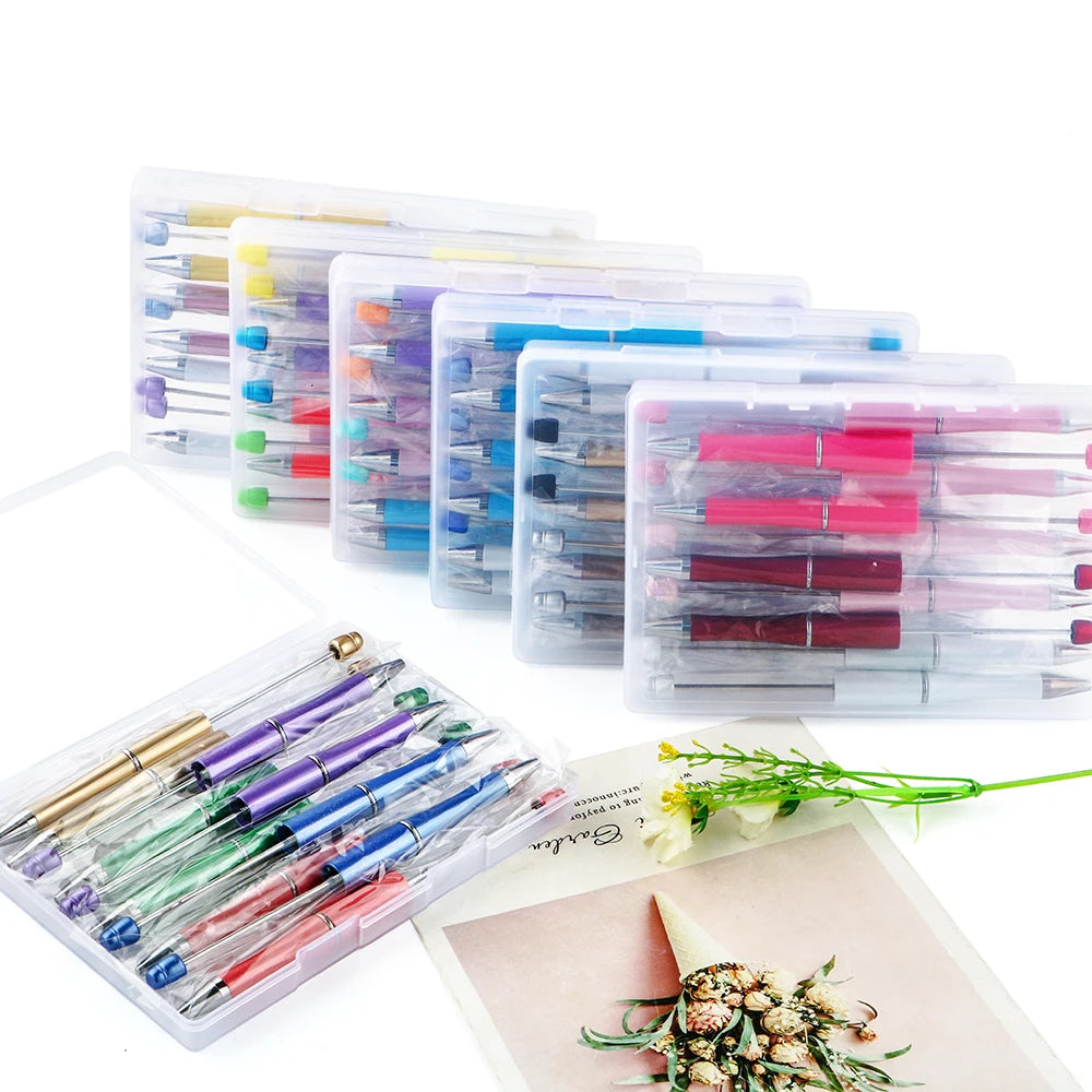 A collection of DIY beaded ballpoint pen kits in various colors and designs displayed on a white background.