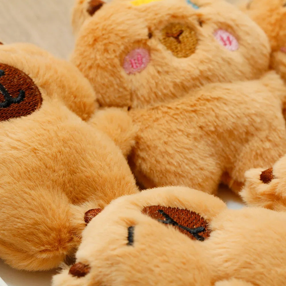 A close-up of several fluffy orange capybara plush toys with pink and brown accents.