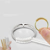 A set of transparent ring size adjusters, including a gold-toned ring and a clear plastic extender, shown next to a hand.