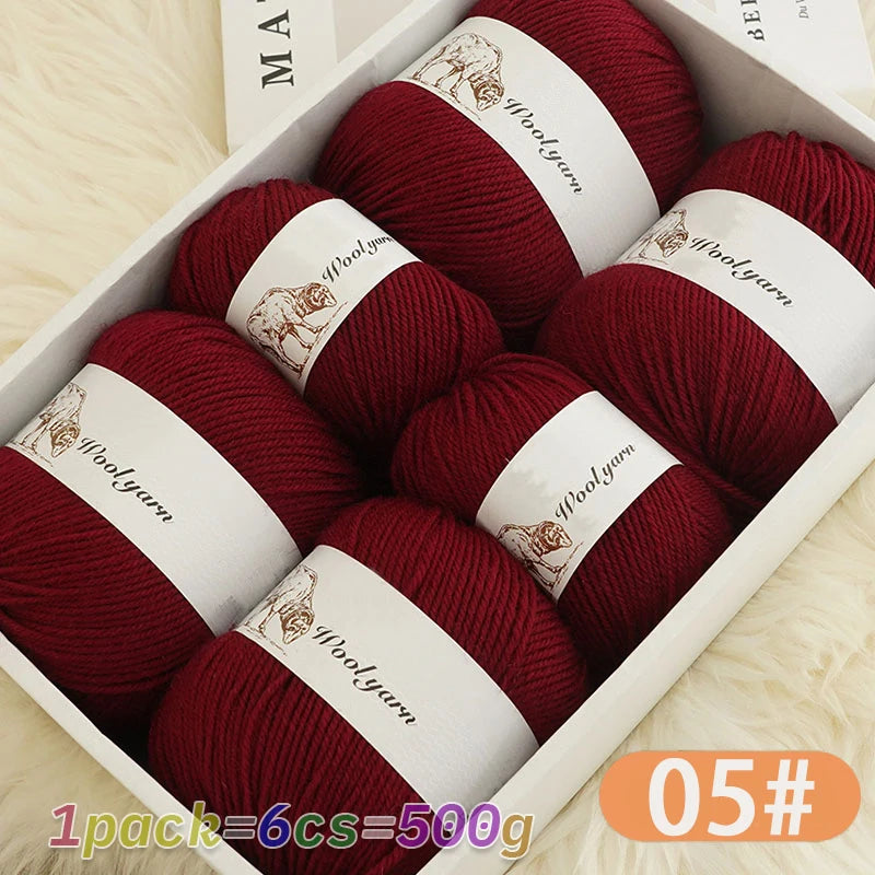A pack of six balls of deep red merino wool yarn for knitting displayed in a white box.