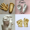 A collection of hand and foot casts in gold and white, including a handprint and a footprint.