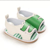 A pair of white and green breathable baby first walker sandals with a soft anti-slip sole.