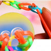 A hand is shown manipulating colorful glow-in-the-dark loom bands for a bracelet making kit.