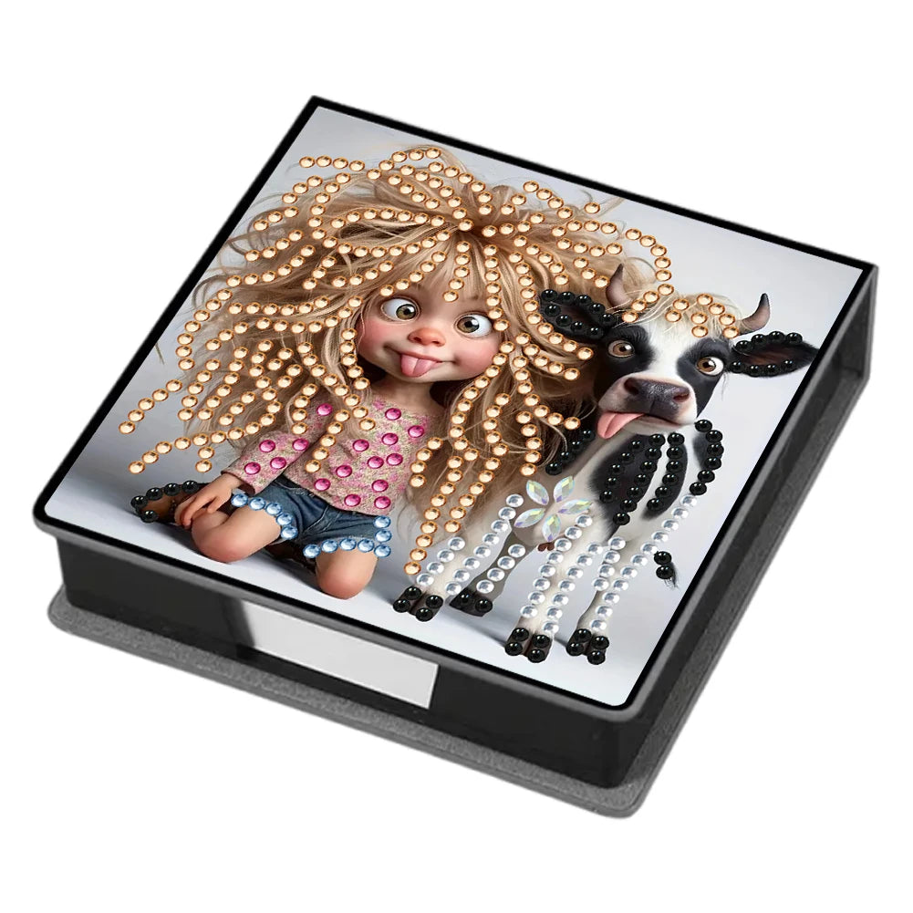 A doll with curly blonde hair adorned with gold beads and a cow figurine is displayed in a black box.