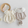 A beige baby girl sleeveless jumpsuit with a white lace collar and matching shoes, displayed on a light background.