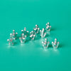 A collection of silver building block treasure chest pieces scattered on a teal surface.