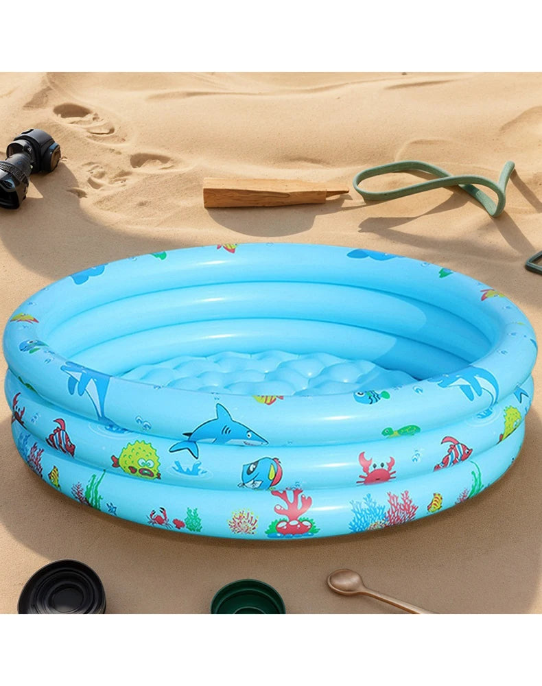 A blue inflatable kids play pool with cartoon fish and sea life resting on sand.