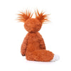 An adorable orange fox plushie with fluffy fur and spiky orange ears lying down.