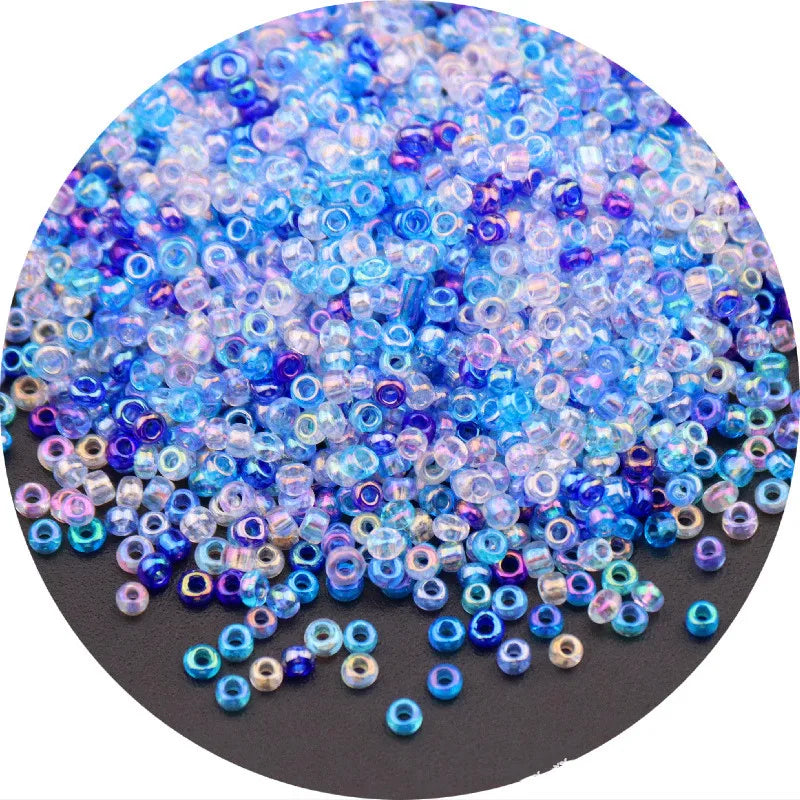 A close-up view of a pile of iridescent blue and purple glass rice beads for crafting.