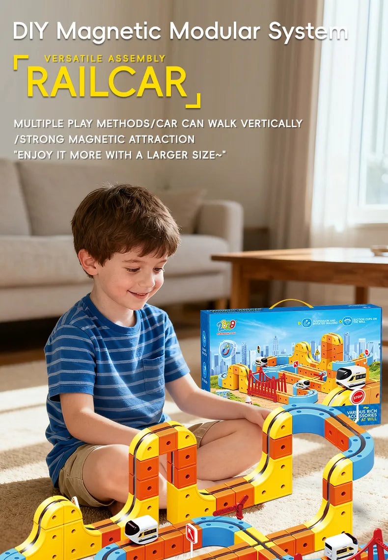 A young boy is playing with a yellow and orange magnetic modular system train set on a carpet.