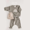 A gray baby girl outfit set featuring a long-sleeve top with a rainbow design and matching sweatpants.