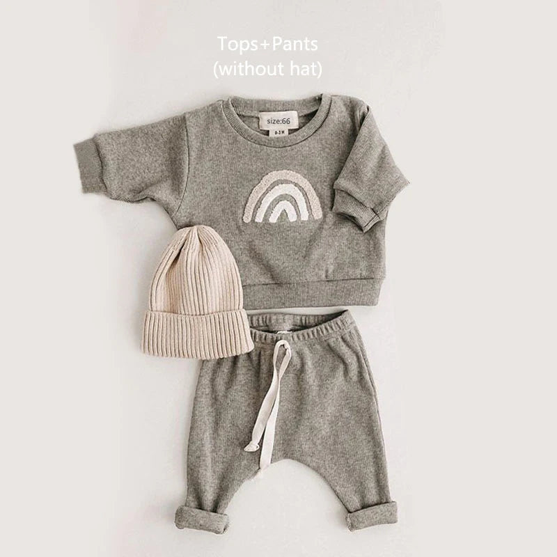 A gray baby girl outfit set featuring a long-sleeve top with a rainbow design and matching sweatpants.
