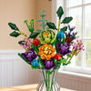 A colorful bouquet of building blocks shaped like flowers and greenery displayed in a glass vase.