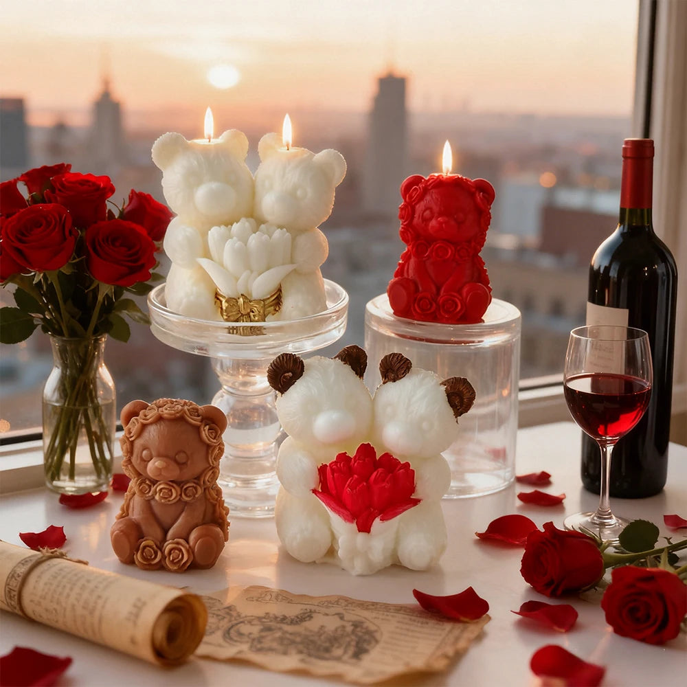 A display of red roses, bear-shaped silicone candles, and a bottle of red wine on a white surface.