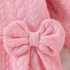 Pink quilted baby girl romper featuring a bow detail and lace collar.