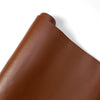 A close-up view of a brown PU leather self-adhesive repair patch.