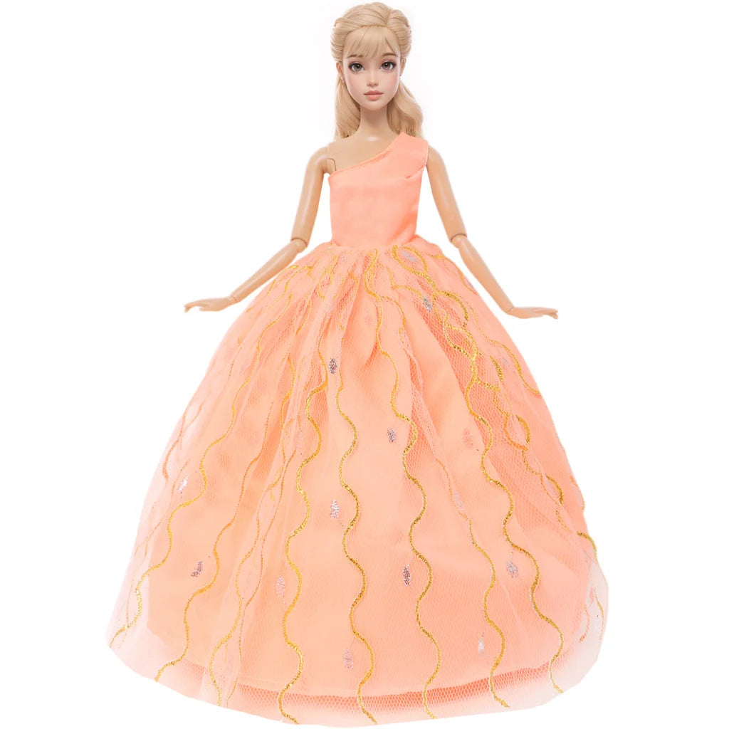 A female doll wearing an elegant peach colored evening gown with gold embroidery and a sweetheart neckline.