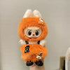 A small doll dressed in an orange pumpkin costume with white fur and black accents.