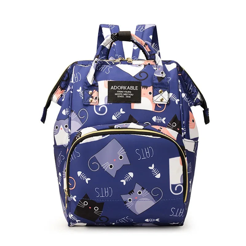 A blue cartoon print waterproof diaper bag with a black strap and multiple compartments.