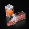Clear plastic storage bottles filled with various colored beads for diamond painting and crafts