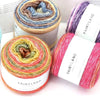 Rolls of Fairyland gradient rainbow yarn showing various colors and textures for knitting and crochet