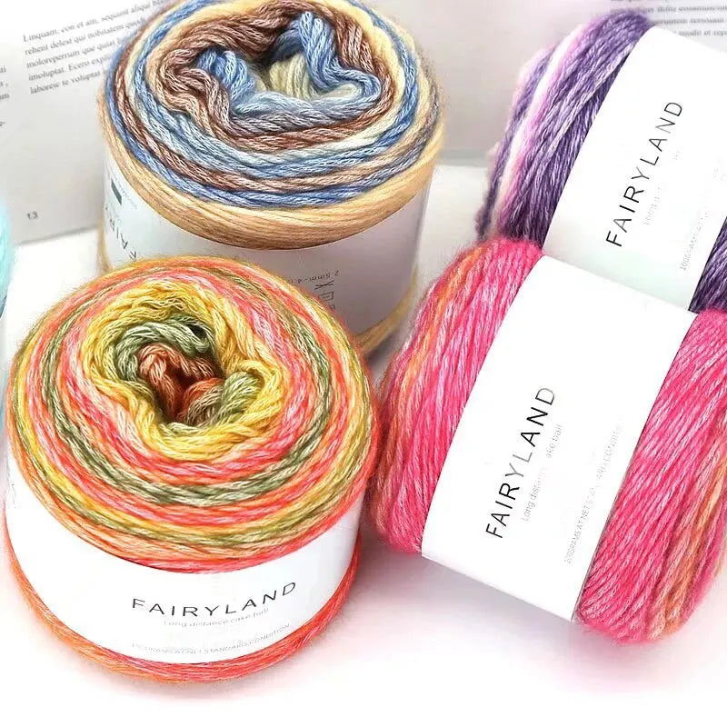 Rolls of Fairyland gradient rainbow yarn showing various colors and textures for knitting and crochet