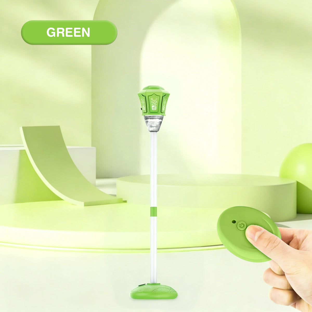 A hand holds a green automatic outdoor bubble machine with lights and music on a white surface.