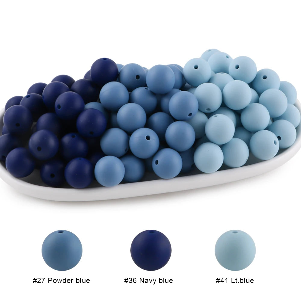 A collection of round silicone beads in various shades of blue, including powder blue, navy blue, and lt.blue.