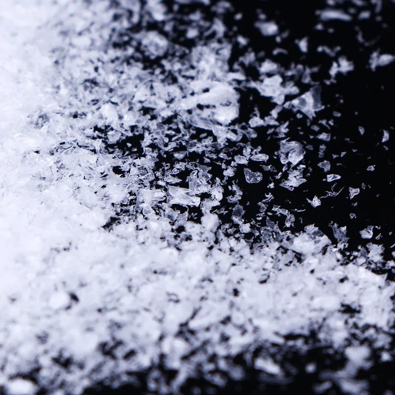 Close-up view of white artificial snow powder scattered on a dark surface.